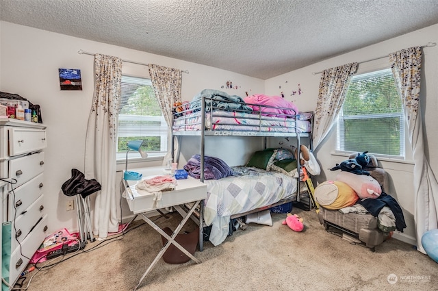 bedroom with carpet floors, a textured ceiling, and multiple windows