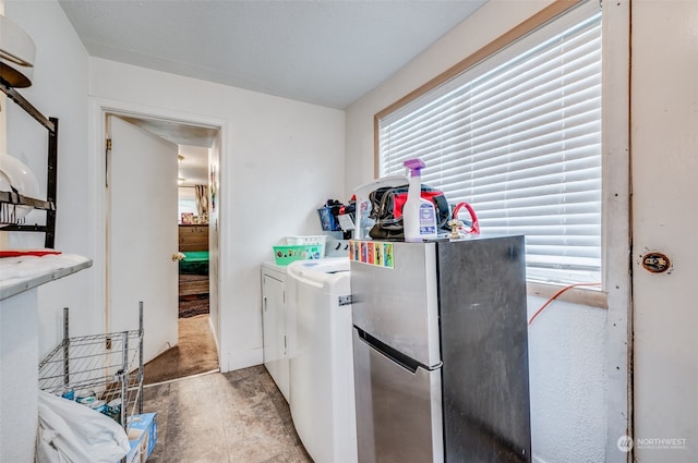 laundry room featuring washer and clothes dryer and a wealth of natural light