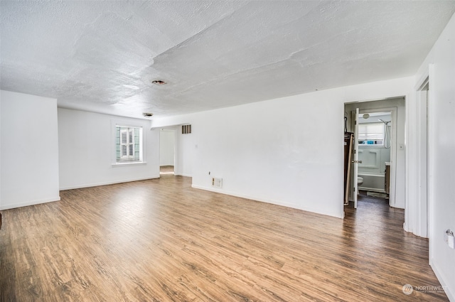 empty room featuring a textured ceiling and hardwood / wood-style flooring