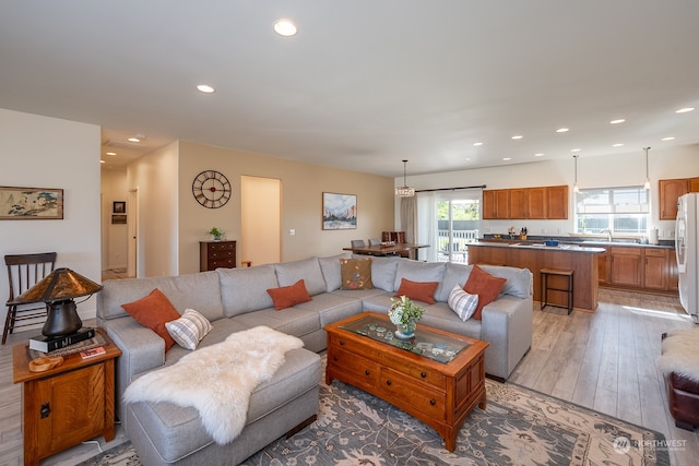 living room with light hardwood / wood-style flooring and sink