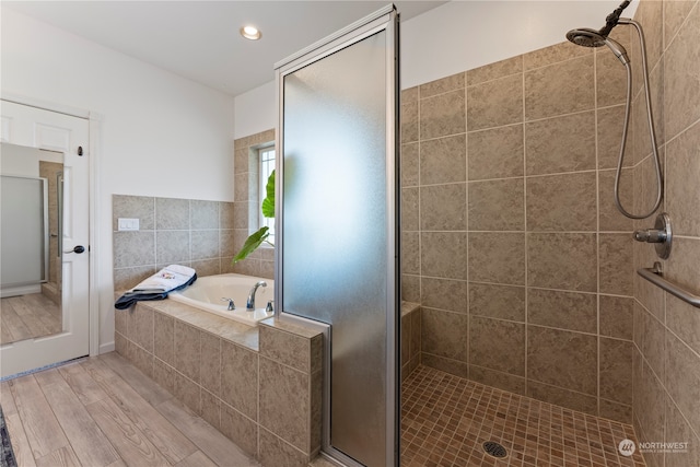 bathroom featuring hardwood / wood-style flooring and separate shower and tub