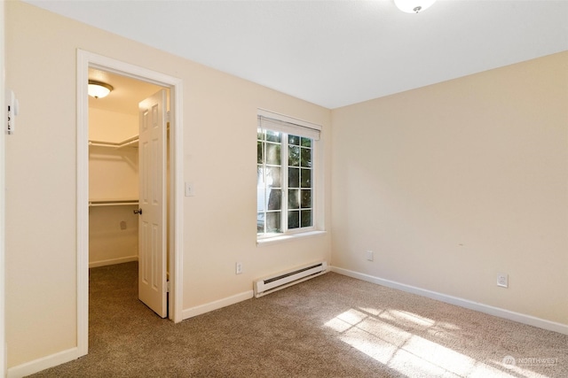 unfurnished bedroom featuring carpet floors, a closet, a walk in closet, and a baseboard radiator