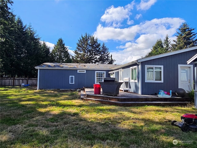 back of house with a deck and a yard