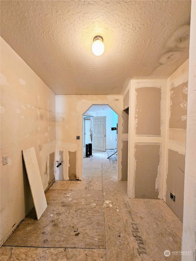 hall featuring a textured ceiling