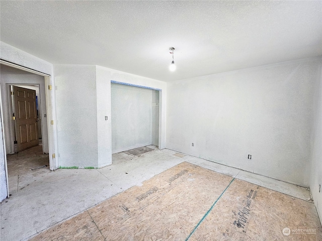 unfurnished bedroom featuring a textured ceiling and a closet