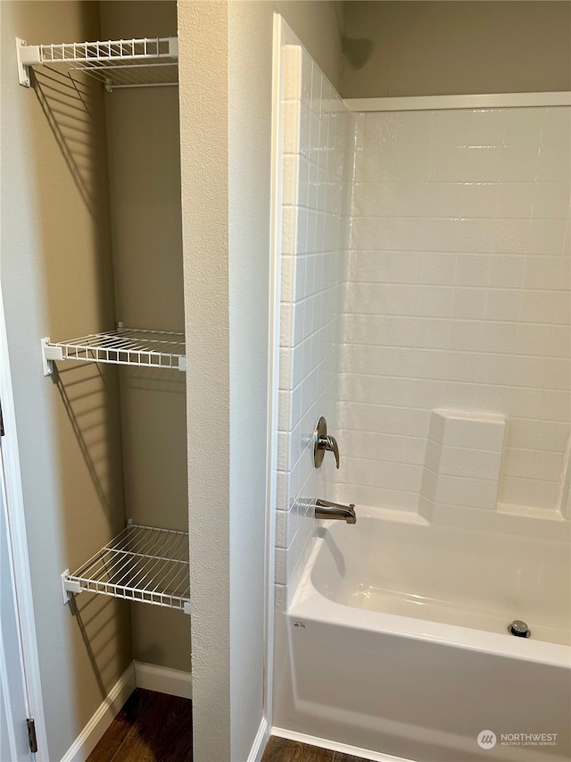 bathroom with wood-type flooring and tub / shower combination