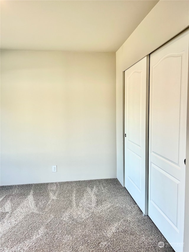 unfurnished bedroom featuring a closet and carpet