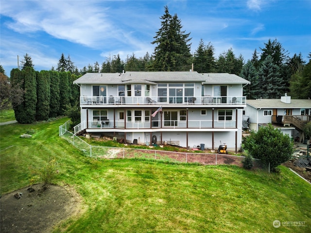 back of house with a balcony and a lawn