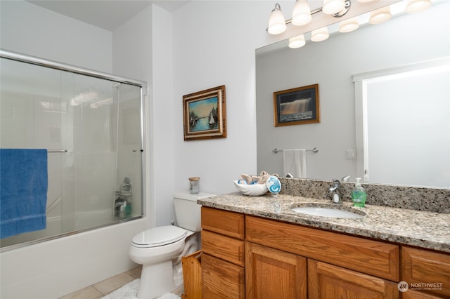 full bathroom featuring enclosed tub / shower combo, vanity, tile patterned flooring, and toilet