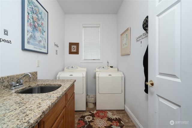 clothes washing area featuring washing machine and dryer, light tile patterned flooring, sink, and cabinets