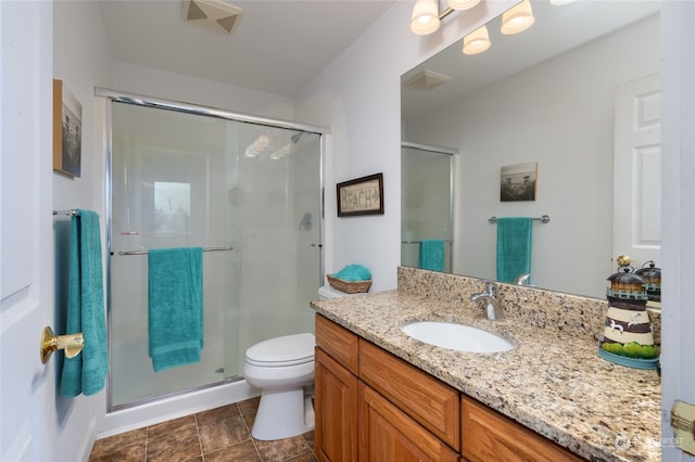 bathroom featuring vanity, toilet, and a shower with door