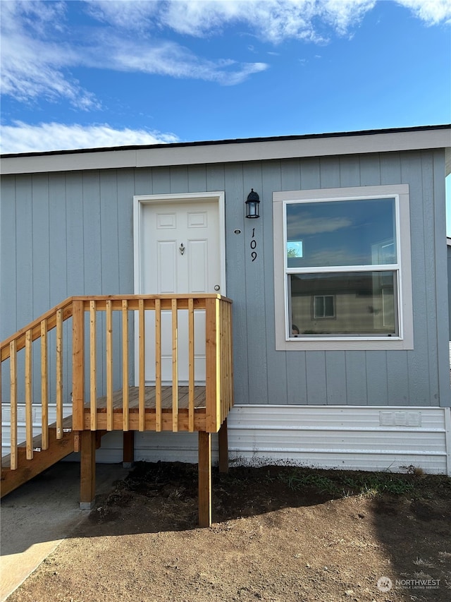 view of exterior entry featuring a wooden deck