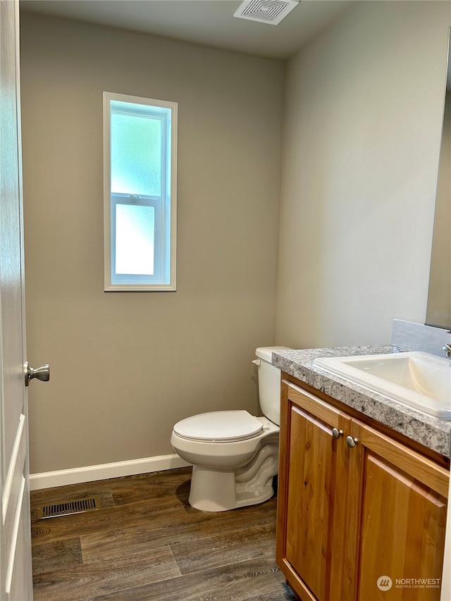 bathroom featuring hardwood / wood-style floors, vanity, and toilet