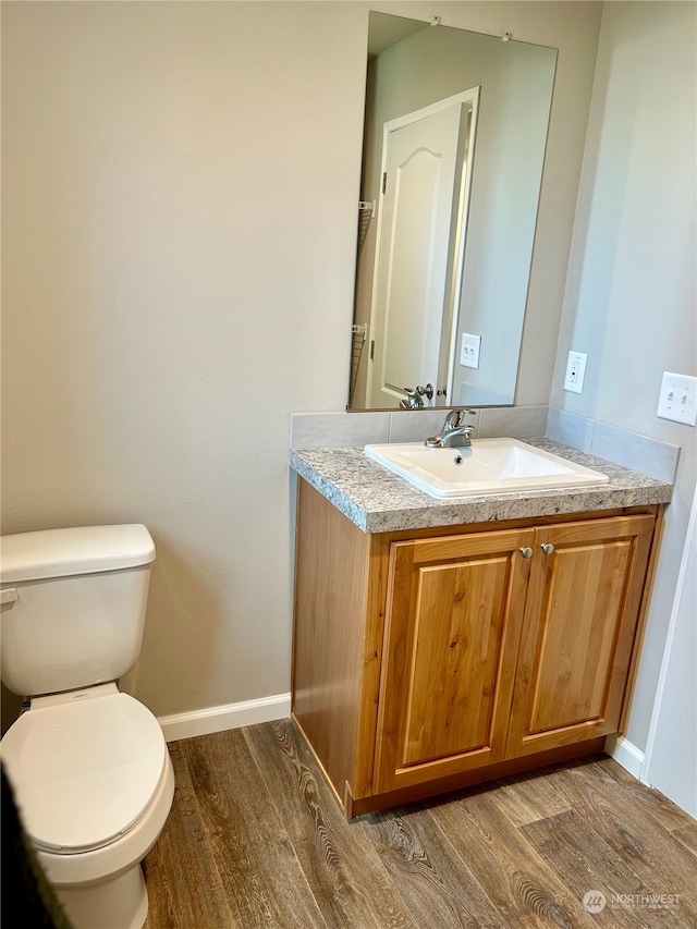 bathroom featuring vanity, toilet, and hardwood / wood-style flooring