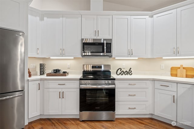 kitchen with white cabinetry, stainless steel appliances, and light wood-type flooring