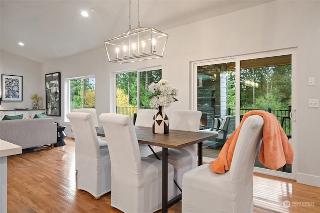 dining space featuring vaulted ceiling and light hardwood / wood-style flooring