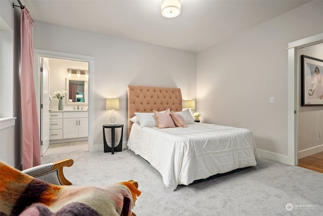 bedroom with sink, light carpet, and ensuite bath