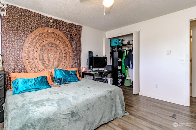 bedroom featuring a textured ceiling, ceiling fan, a closet, and wood-type flooring