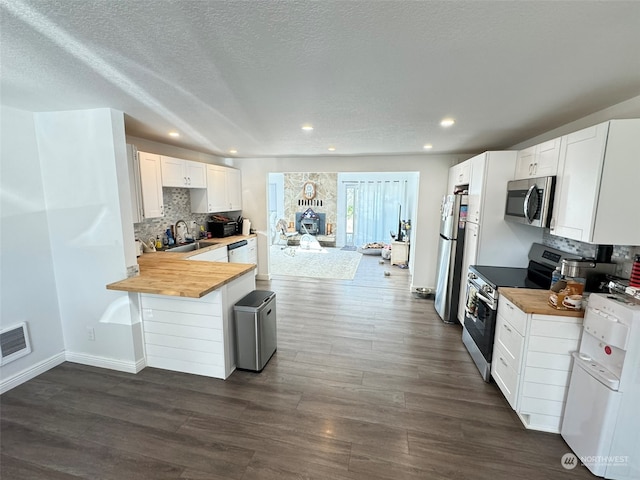 kitchen featuring butcher block countertops, appliances with stainless steel finishes, and white cabinetry