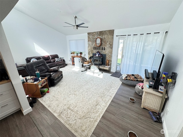 living room featuring ceiling fan, dark hardwood / wood-style flooring, and a wood stove