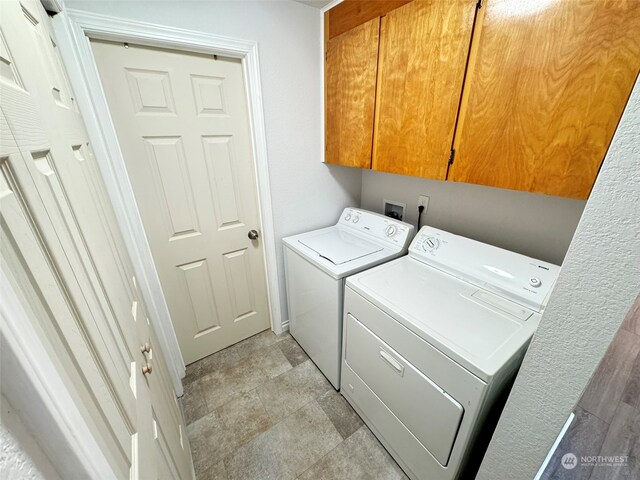 laundry room with washer and clothes dryer and cabinets