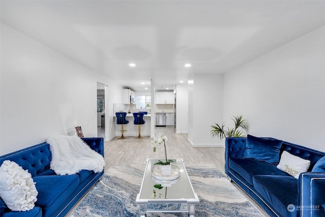 living room featuring light wood-type flooring, recessed lighting, and baseboards
