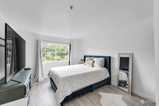 bedroom with light wood-style flooring and baseboards