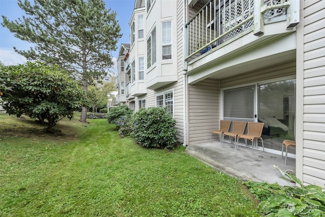 view of yard with a balcony and a patio