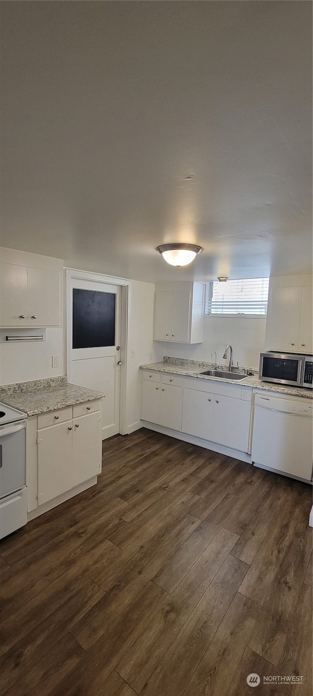 kitchen featuring white electric range oven, dark wood-type flooring, sink, and white cabinetry