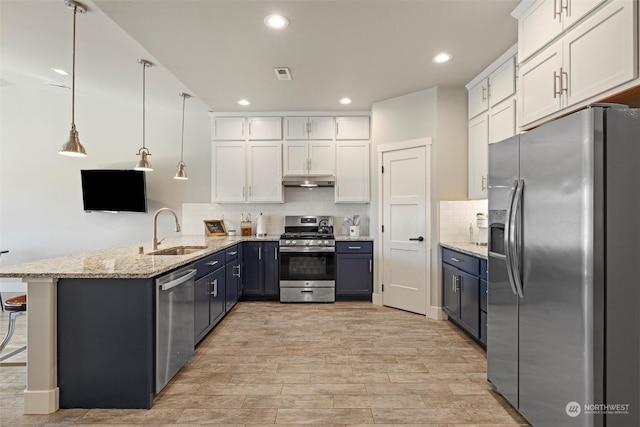 131 Sonoma Pl, Walla Walla, WA 99362 - kitchen featuring under cabinet range hood, a sink, white cabinets, a peninsula, and appliances with stainless steel finishes