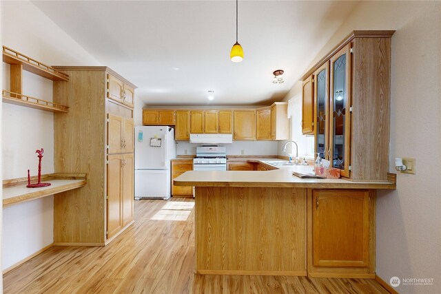 kitchen featuring sink, pendant lighting, white appliances, and kitchen peninsula