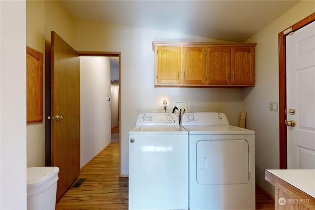 laundry area with cabinets, light hardwood / wood-style flooring, and washer and dryer