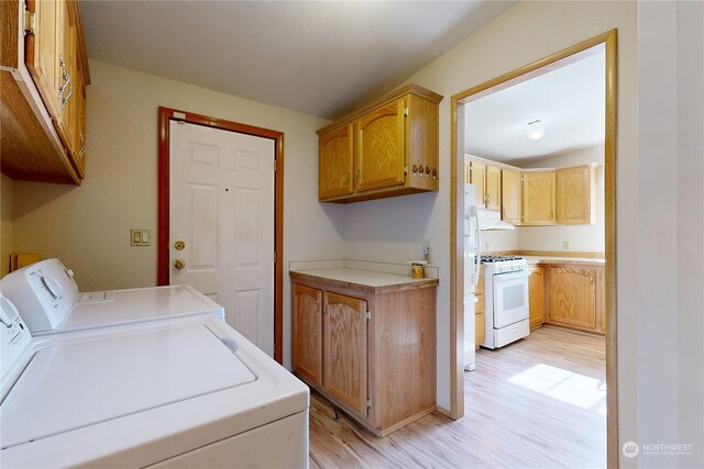 clothes washing area featuring independent washer and dryer and light wood-type flooring