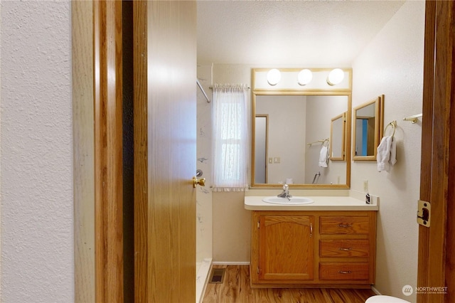 1370 Samuel Dr, Walla Walla, WA 99362 - bathroom with vanity, wood finished floors, and a textured wall