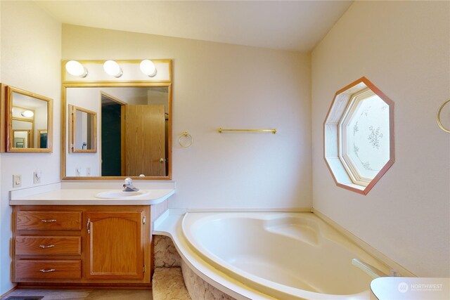 bathroom with vanity and a relaxing tiled tub