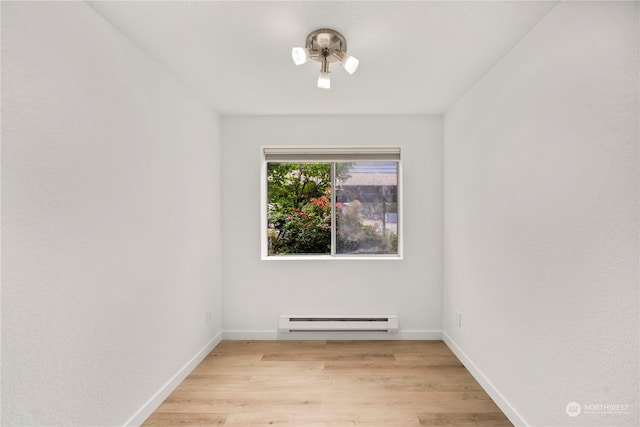 spare room featuring a baseboard radiator and light wood-type flooring