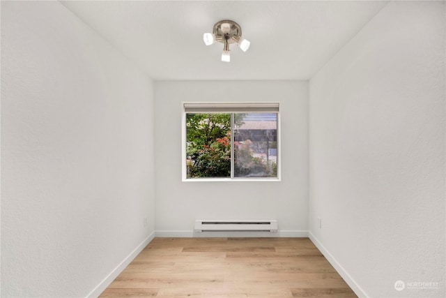 unfurnished room with baseboards, light wood-style flooring, and a baseboard radiator