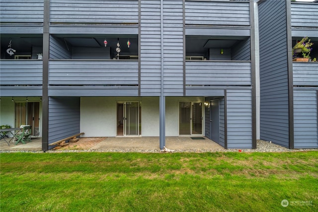 rear view of property with a yard and a balcony