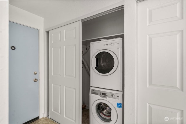 clothes washing area with stacked washing maching and dryer