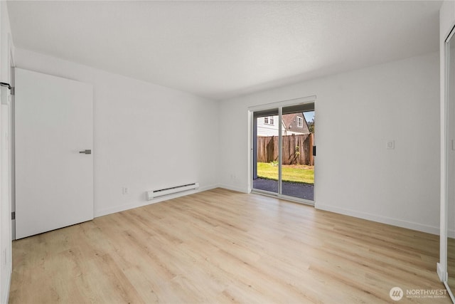 interior space with baseboards, access to exterior, a baseboard heating unit, and wood finished floors