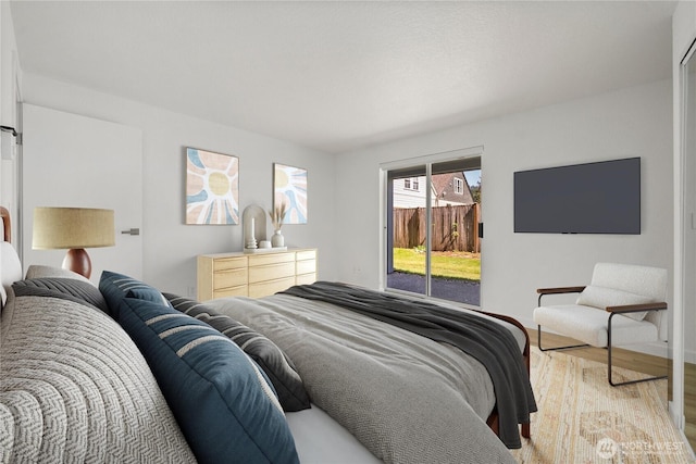 bedroom featuring access to outside, light wood-style flooring, and baseboards