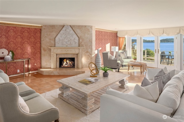 living room with a water view, a premium fireplace, and light tile patterned floors