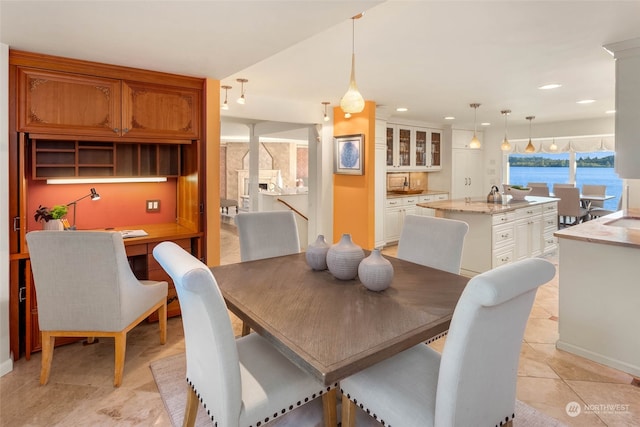 tiled dining room featuring a water view