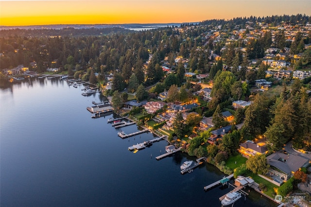 aerial view at dusk featuring a water view