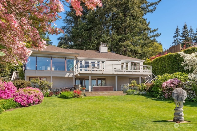 back of house featuring a wooden deck and a yard