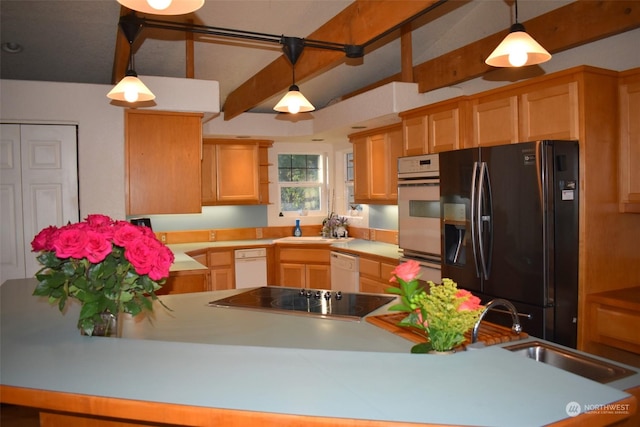 kitchen featuring black fridge, sink, decorative light fixtures, wall oven, and cooktop