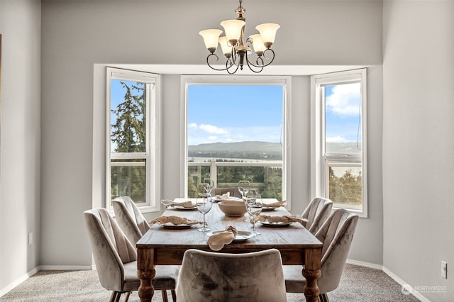 dining room with carpet floors, a mountain view, plenty of natural light, and a chandelier