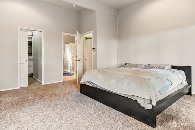 carpeted bedroom featuring connected bathroom, a spacious closet, and a closet