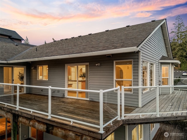 back house at dusk with a deck