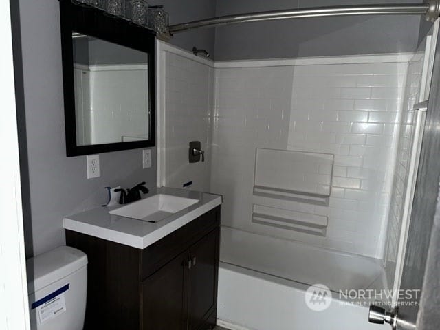 full bathroom with toilet, tiled shower / bath combo, and vanity